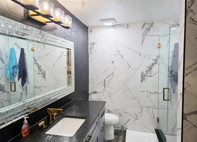 a bathroom with a sink toilet and shower