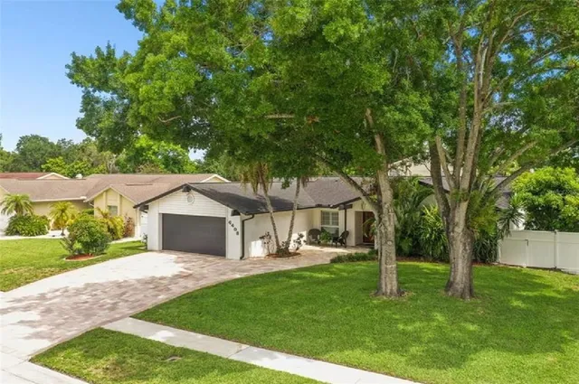 a view of a house with a yard and tree s