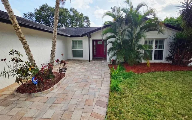 a view of a house with a yard and potted plants