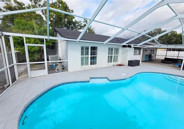 a view of a house with pool fire pit and chairs in front of it