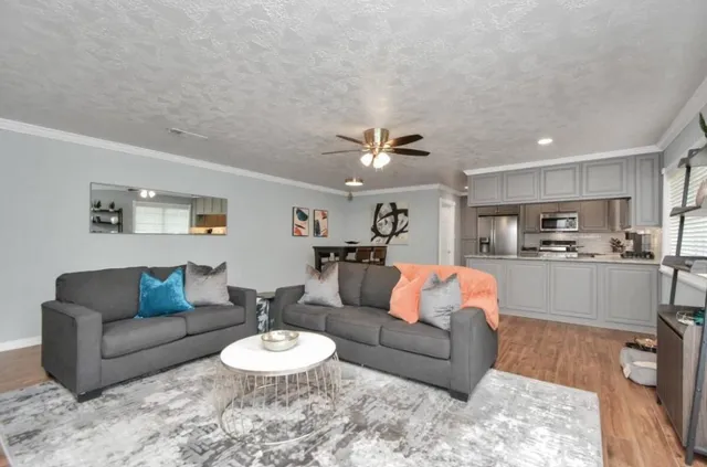 a living room with furniture and a view of kitchen