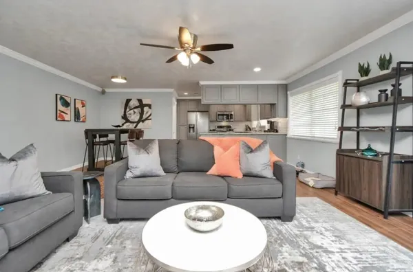a living room with furniture a ceiling fan and a window