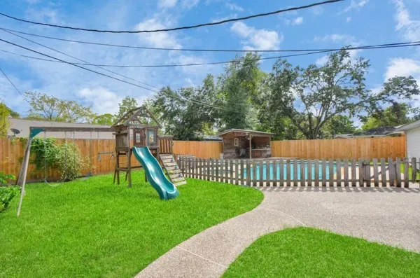 a view of a house with a small yard and wooden fence