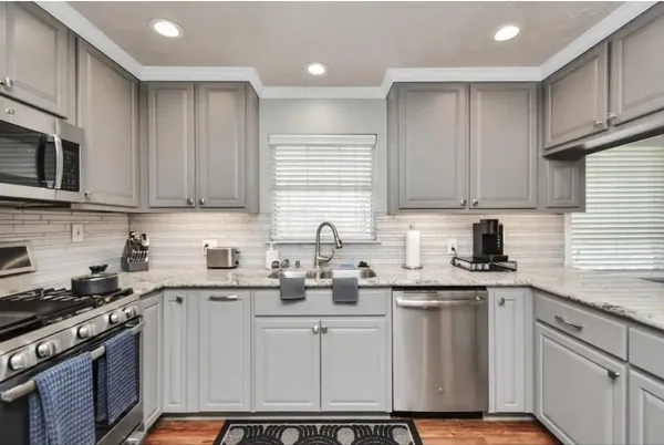 a kitchen with stainless steel appliances granite countertop a sink stove and cabinets