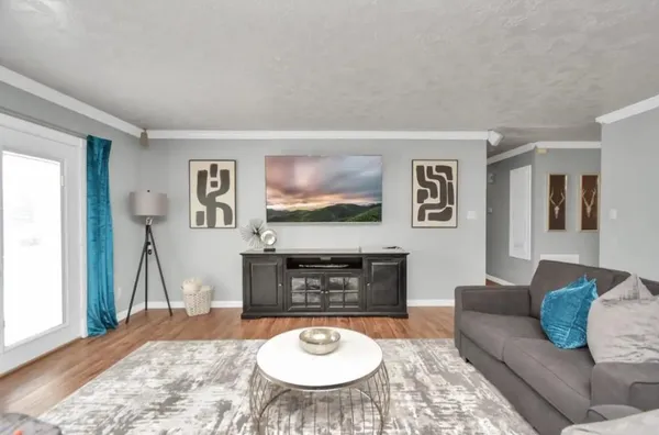 a living room with furniture and a wooden floor