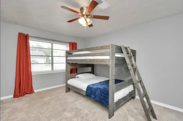 a bedroom with a bed and a ceiling fan