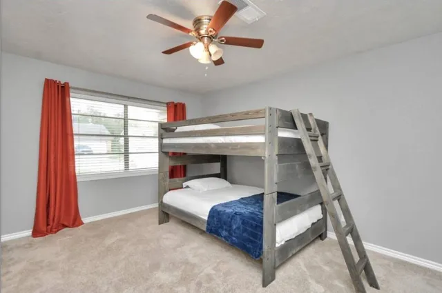 a bedroom with a bed and a ceiling fan