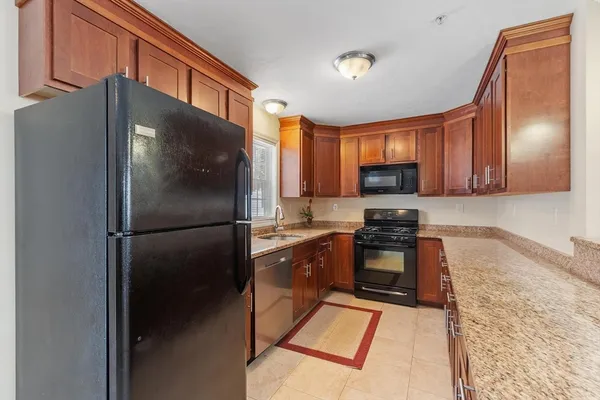 a kitchen with granite countertop stainless steel appliances a refrigerator a stove top oven and granite countertops