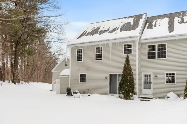a front view of a house with a yard covered in snow