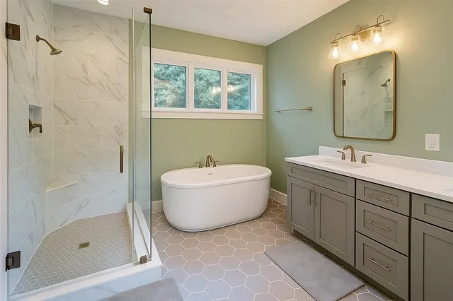 a bathroom with a tub a sink and a mirror