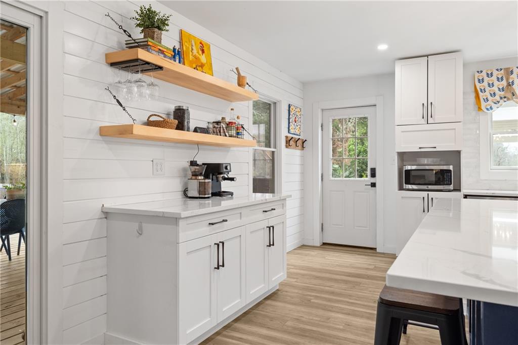 4535 South Barnett Shoals Road Athens, GA 30605 - Photo 12 of 60 a kitchen with stainless steel appliances a white cabinets wooden floors and a sink