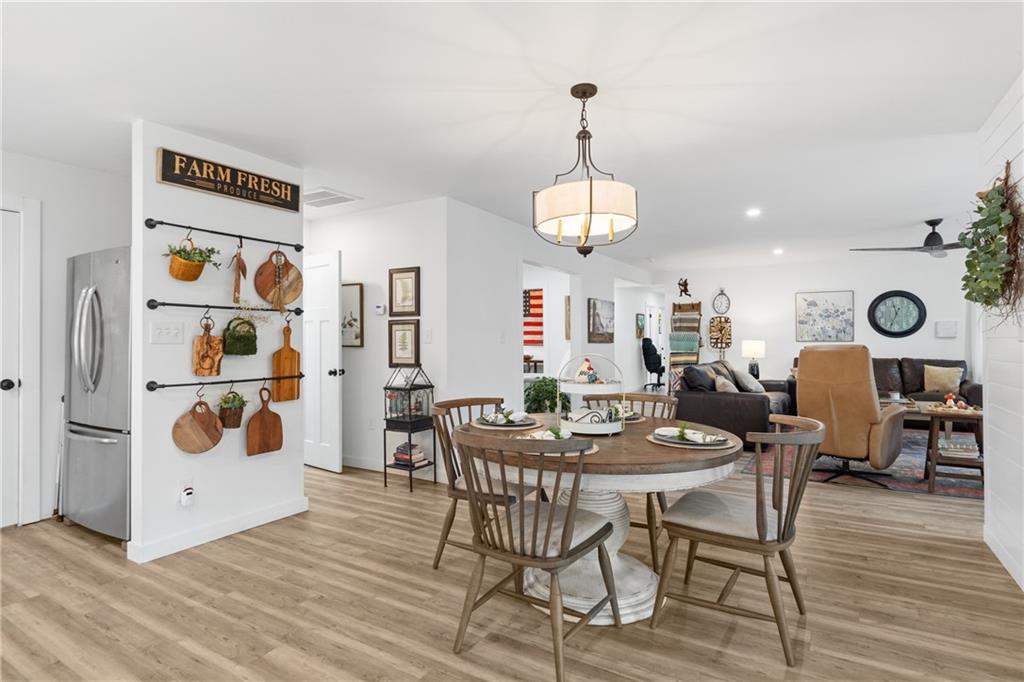 4535 South Barnett Shoals Road Athens, GA 30605 - Photo 13 of 60 a view of a dining room and livingroom with furniture wooden floor chandelier