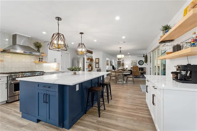 a living room with furniture kitchen view and a wooden floor
