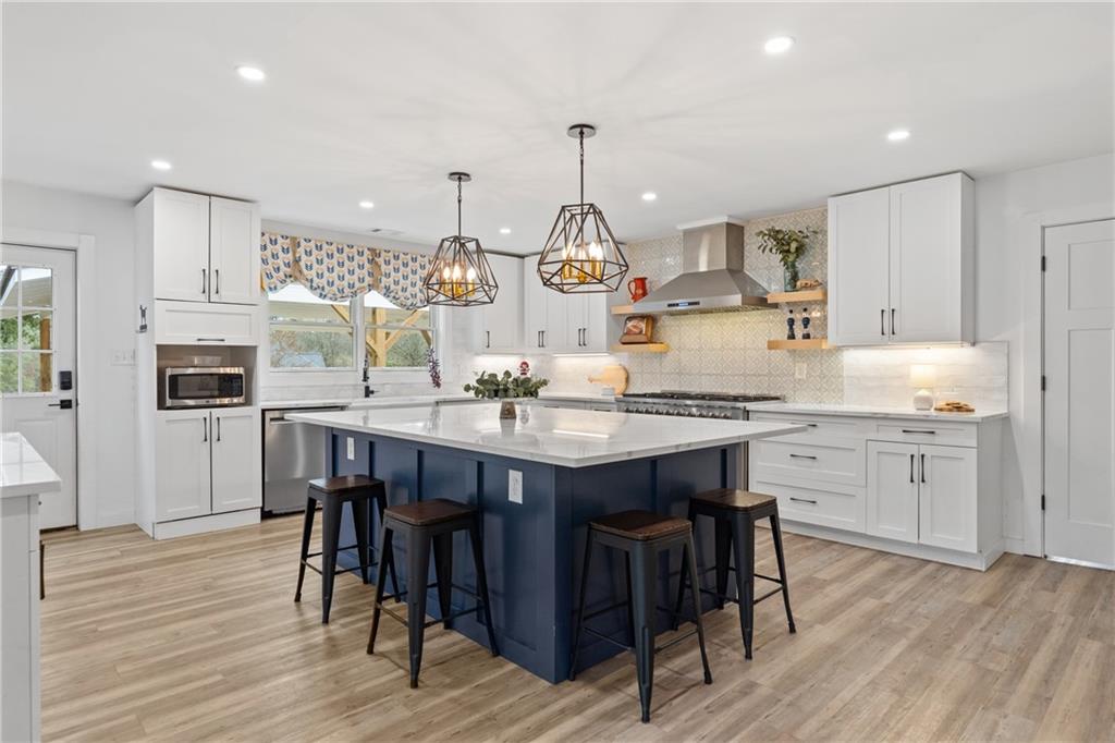 4535 South Barnett Shoals Road Athens, GA 30605 - Photo 7 of 60 a kitchen with kitchen island granite countertop a table chairs sink and cabinets