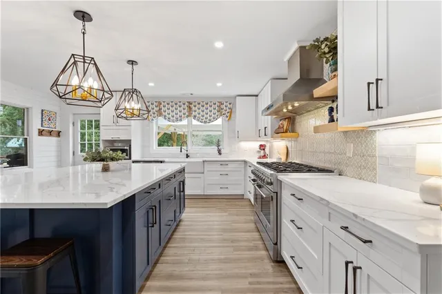 a kitchen with stainless steel appliances a white cabinets wooden floors and a sink