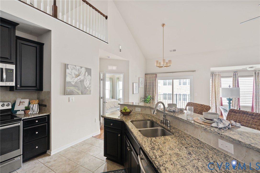 1201 Westwood Village Lane, Unit 402 Midlothian, VA 23114 - Photo 13 of 27 a kitchen with granite countertop a sink and a refrigerator
