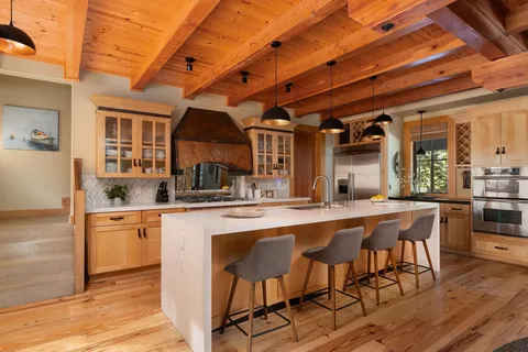 a kitchen with stainless steel appliances granite countertop a table chairs sink and cabinets