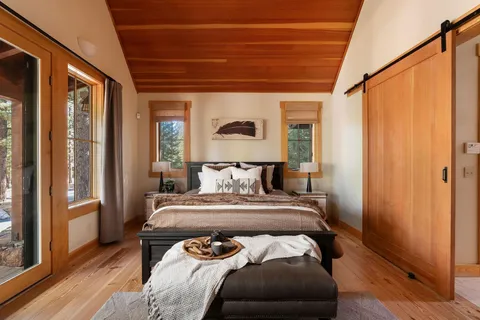 a view of a bedroom with a bed and wooden floor