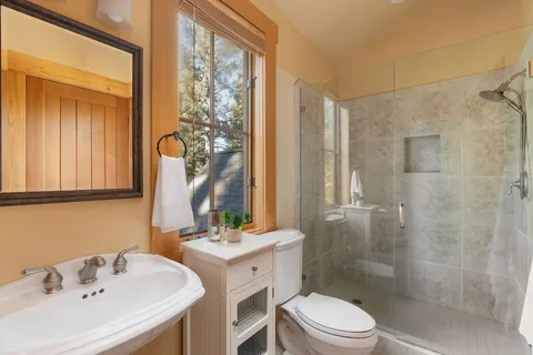 a bathroom with a sink toilet a mirror and shower