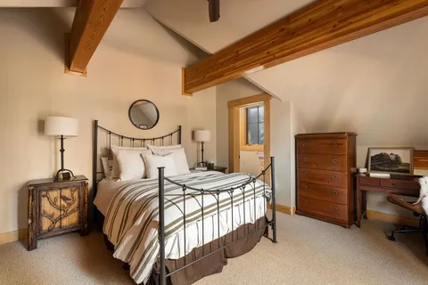 a bedroom with a bed and a lamp on dresser