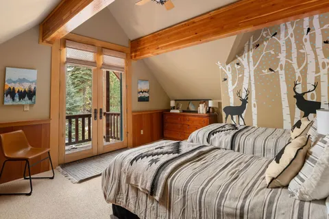 a bedroom with a bed a chair and next to a window