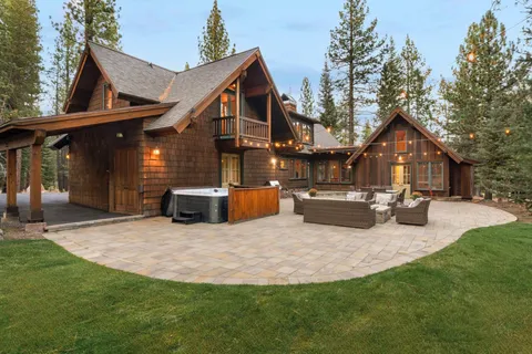 a view of a house with table and chairs in patio