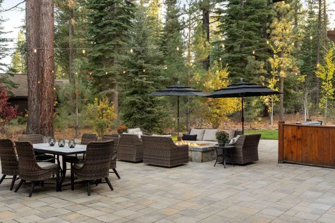 a view of a patio with couches and chairs under an umbrella
