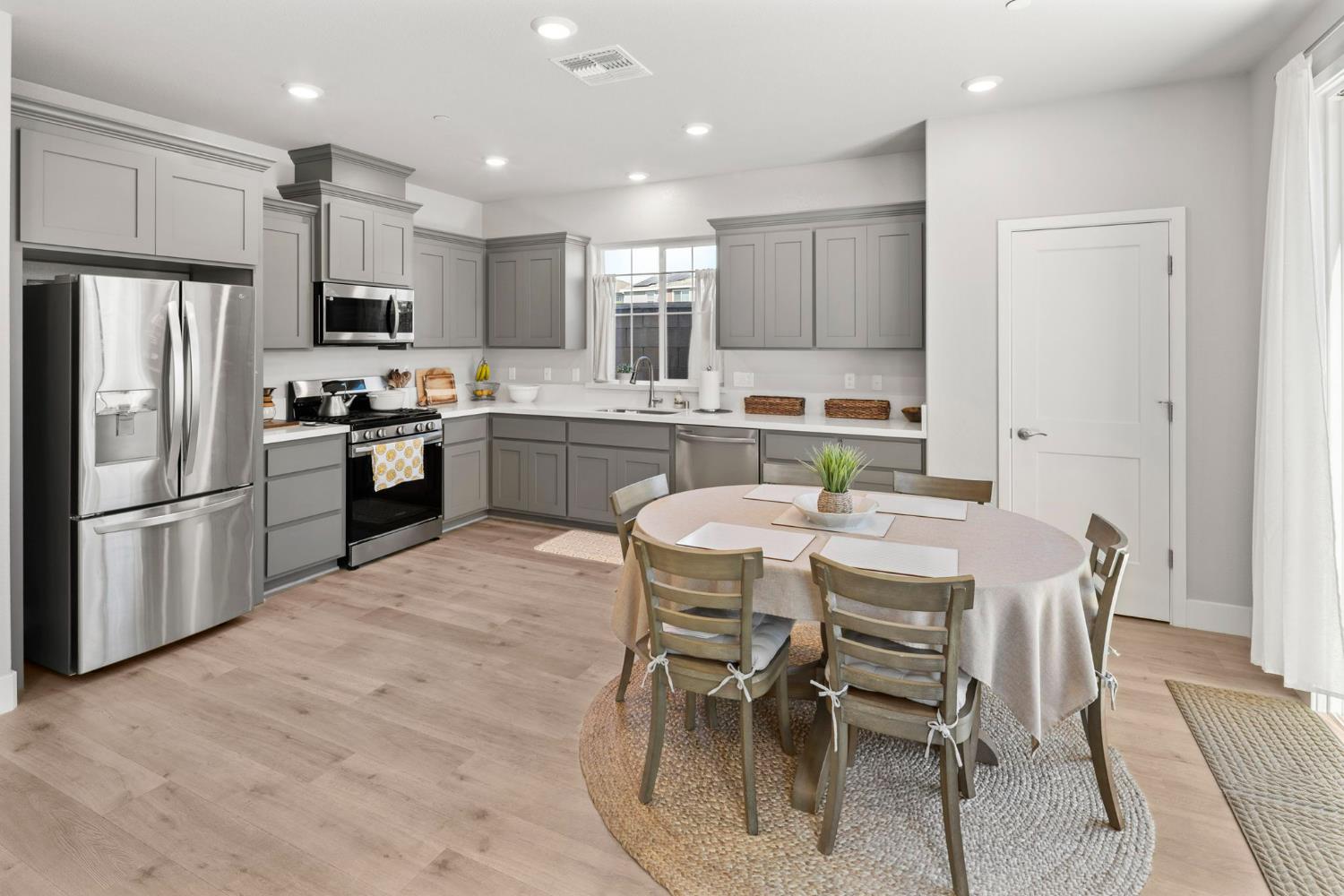 1508 Westwind Way Rocklin, CA 95765 - Photo 10 of 45 a kitchen with stainless steel appliances granite countertop a stove top oven a refrigerator a sink a dining table and chairs