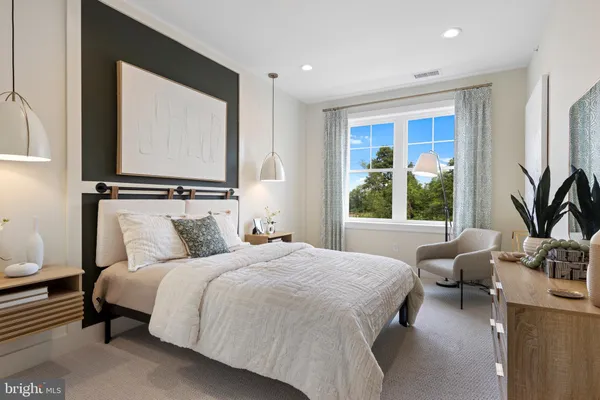 a bedroom with bed couch and window