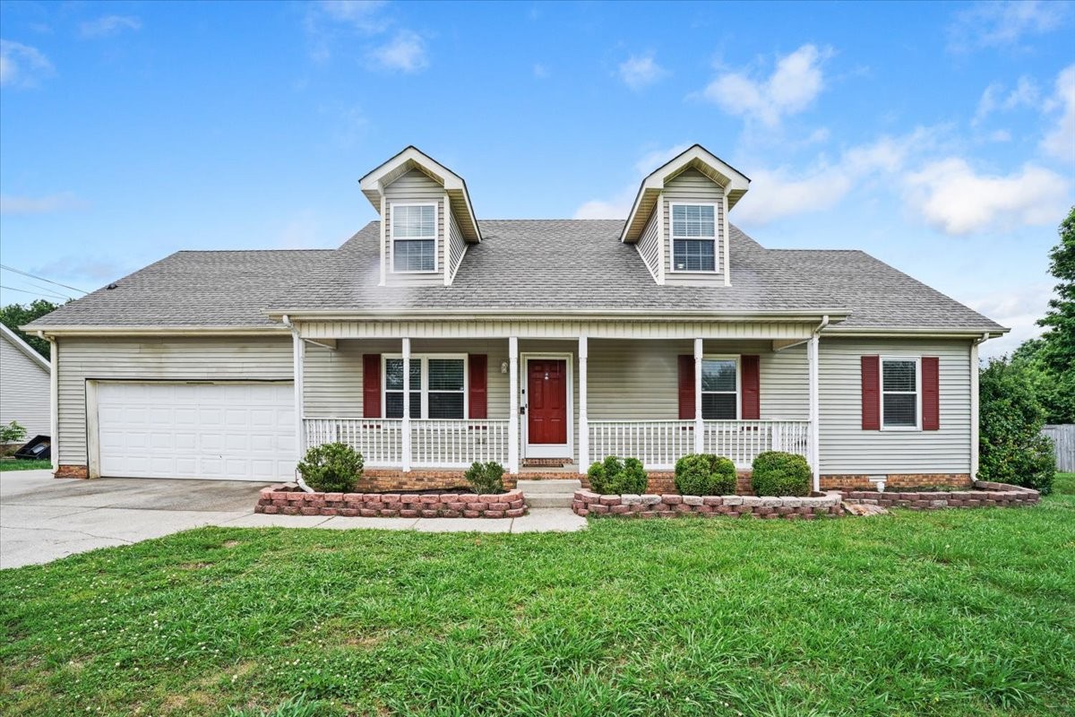 a front view of a house with a yard and potted plants
