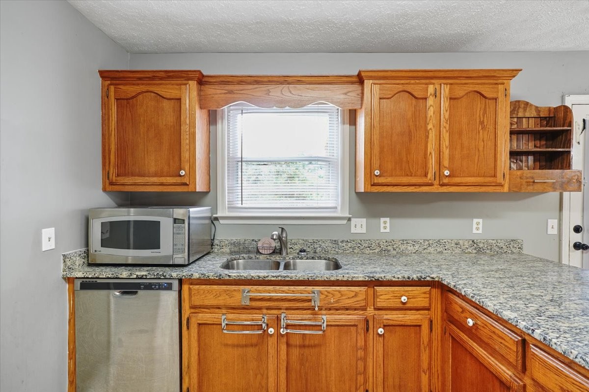 1306 Cason Trail Murfreesboro, TN 37128 - Photo 9 of 38 a kitchen with stainless steel appliances granite countertop a sink stove and microwave