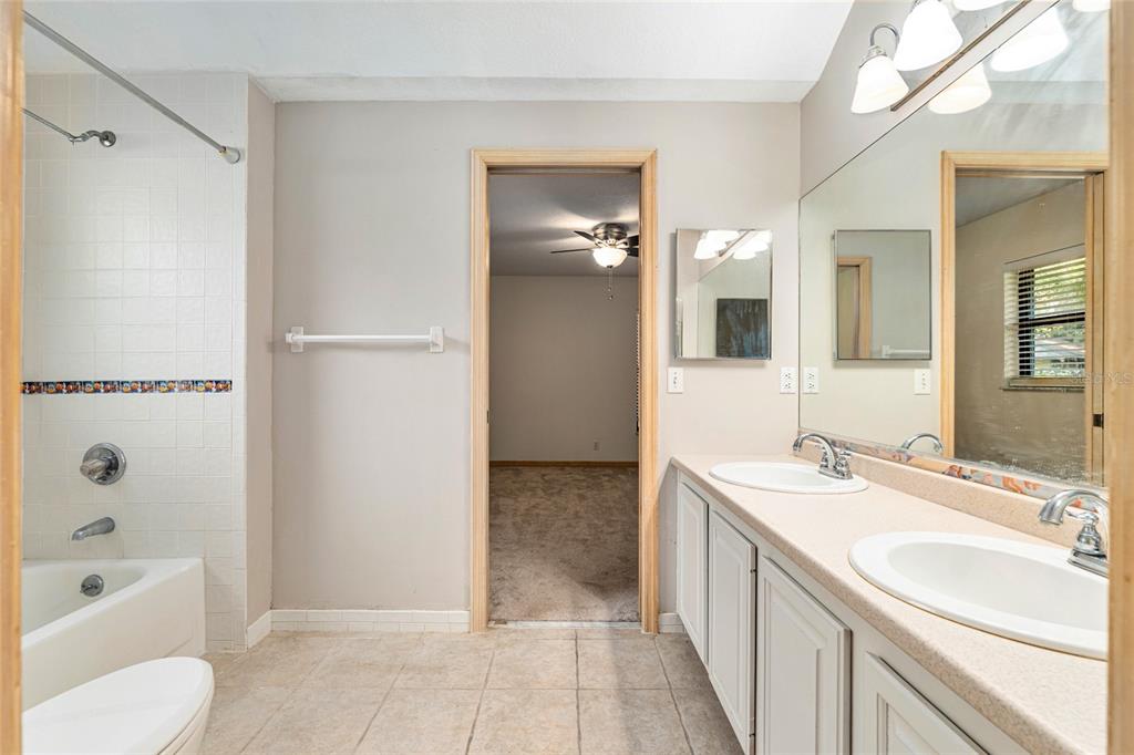 2023 Southwest 76 Terrace Gainesville, FL 32607 - Photo 26 of 95 a bathroom with a tub sink and mirror