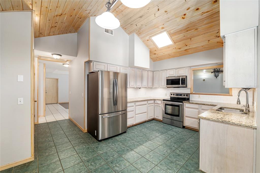 2023 Southwest 76 Terrace Gainesville, FL 32607 - Photo 35 of 95 a kitchen with stainless steel appliances granite countertop a refrigerator a stove a sink and dishwasher