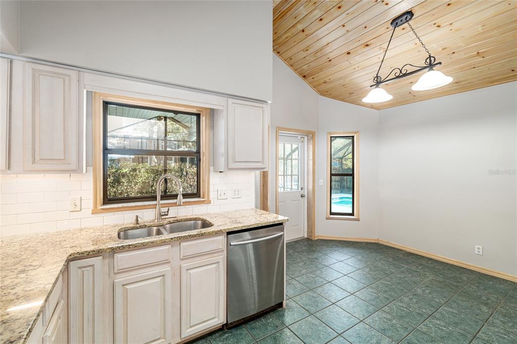 2023 Southwest 76 Terrace Gainesville, FL 32607 - Photo 38 of 95 a kitchen with stainless steel appliances granite countertop a sink a stove a washer and dryer next to a window