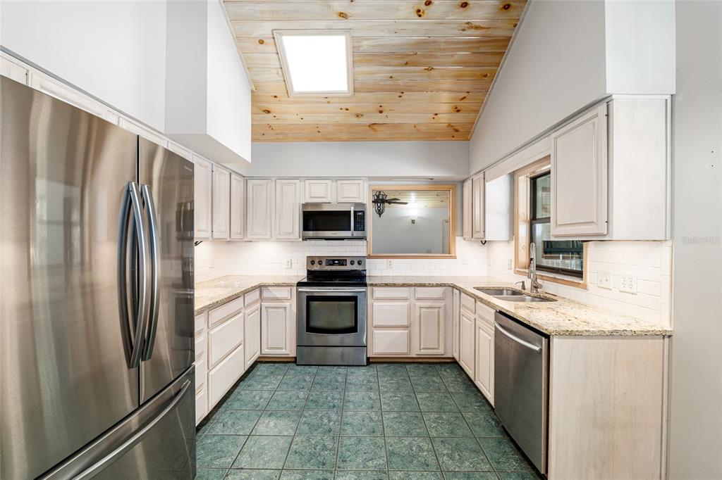 2023 Southwest 76 Terrace Gainesville, FL 32607 - Photo 39 of 95 a kitchen with stainless steel appliances granite countertop a refrigerator a stove top oven and sink