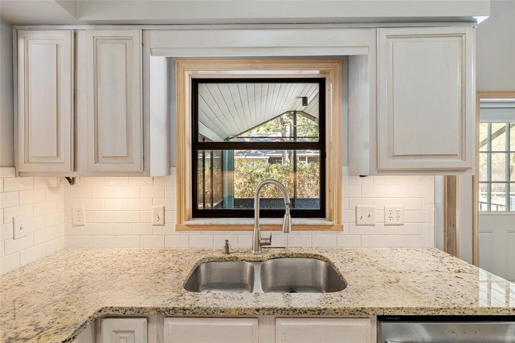 2023 Southwest 76 Terrace Gainesville, FL 32607 - Photo 41 of 95 a kitchen with granite countertop a sink window and cabinets