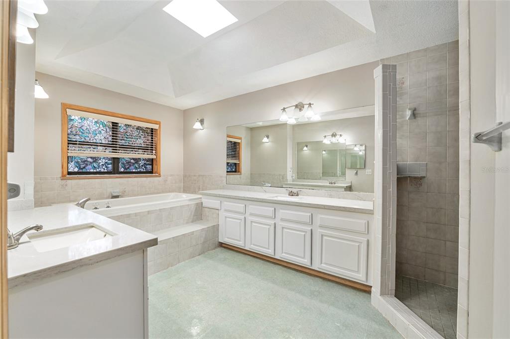 2023 Southwest 76 Terrace Gainesville, FL 32607 - Photo 49 of 95 a large bathroom with a double vanity sink a large mirror and a bathtub
