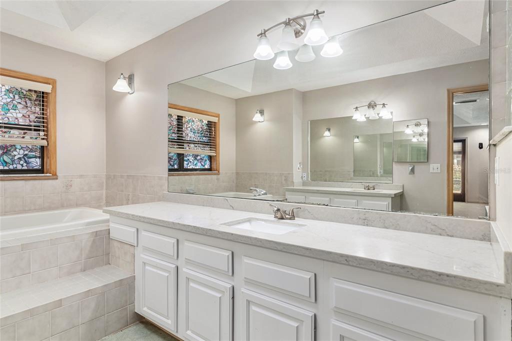 2023 Southwest 76 Terrace Gainesville, FL 32607 - Photo 51 of 95 a bathroom with a sink a large mirror and a bathtub