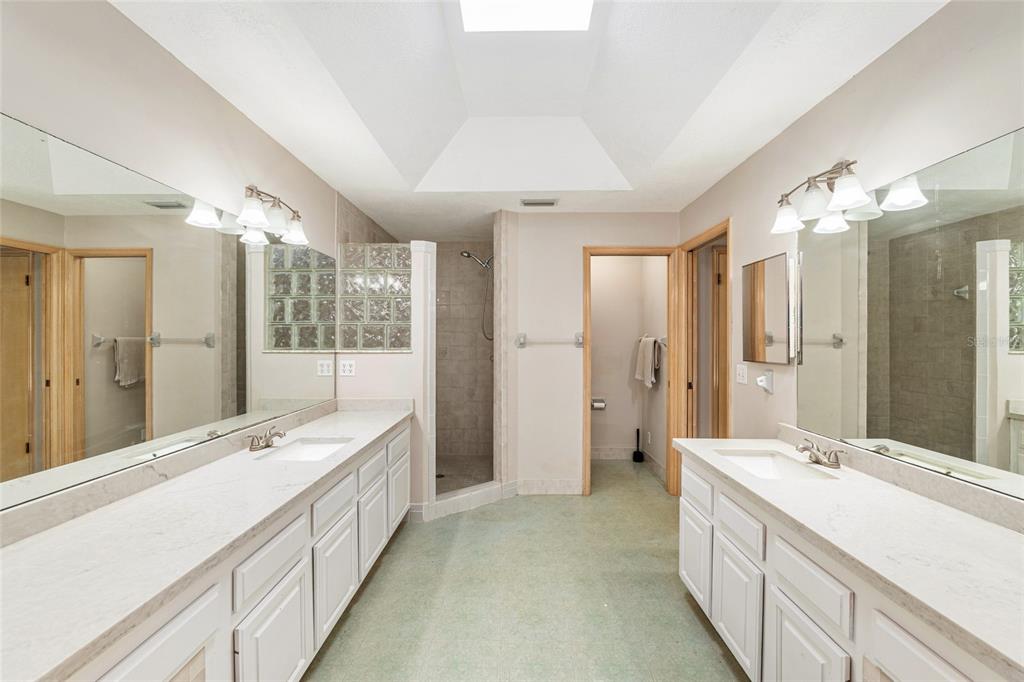 2023 Southwest 76 Terrace Gainesville, FL 32607 - Photo 54 of 95 a spacious bathroom with a double vanity sink shower and a mirror