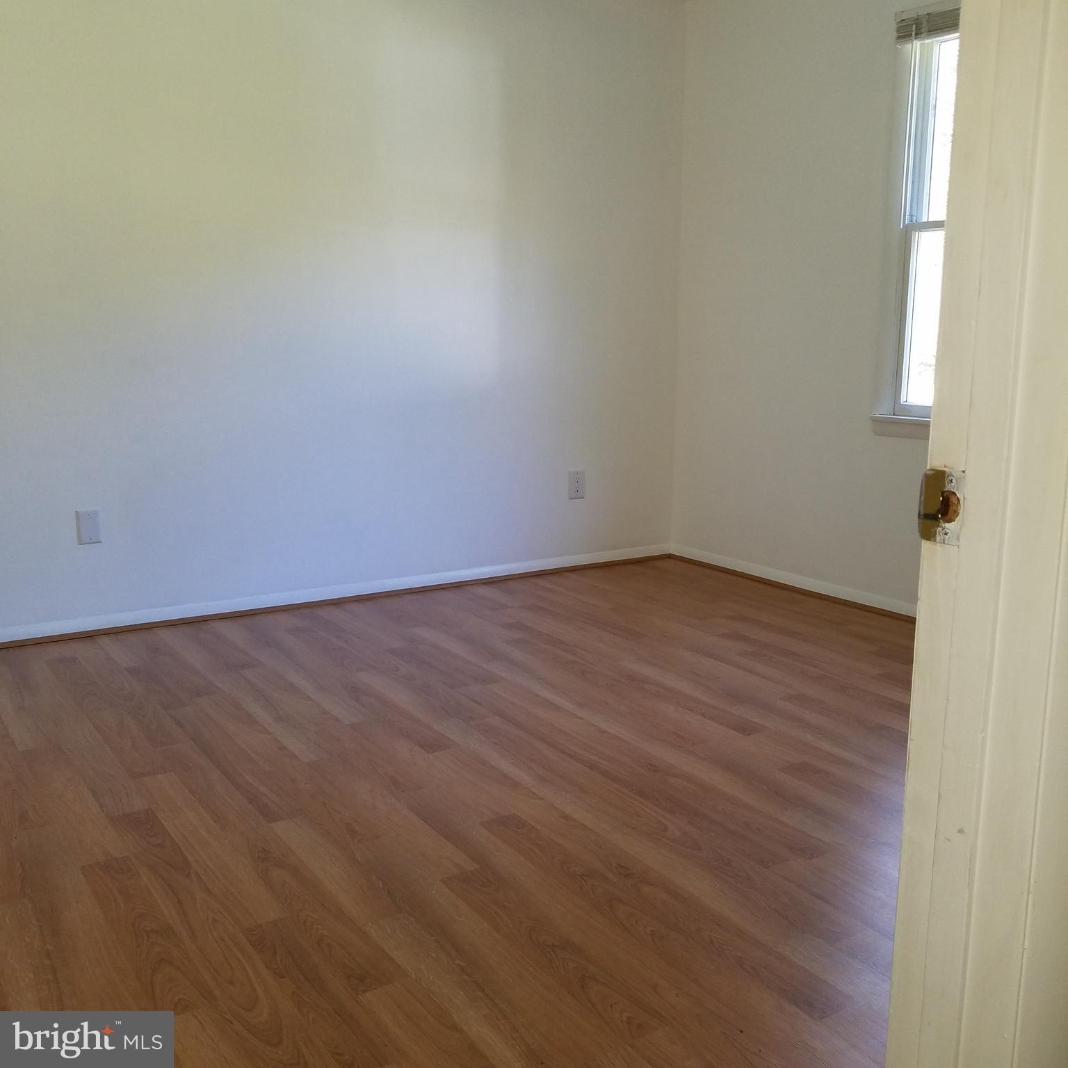 5460 Bethlehem Road Preston, MD 21655 - Photo 12 of 25 an empty room with wooden floor and windows