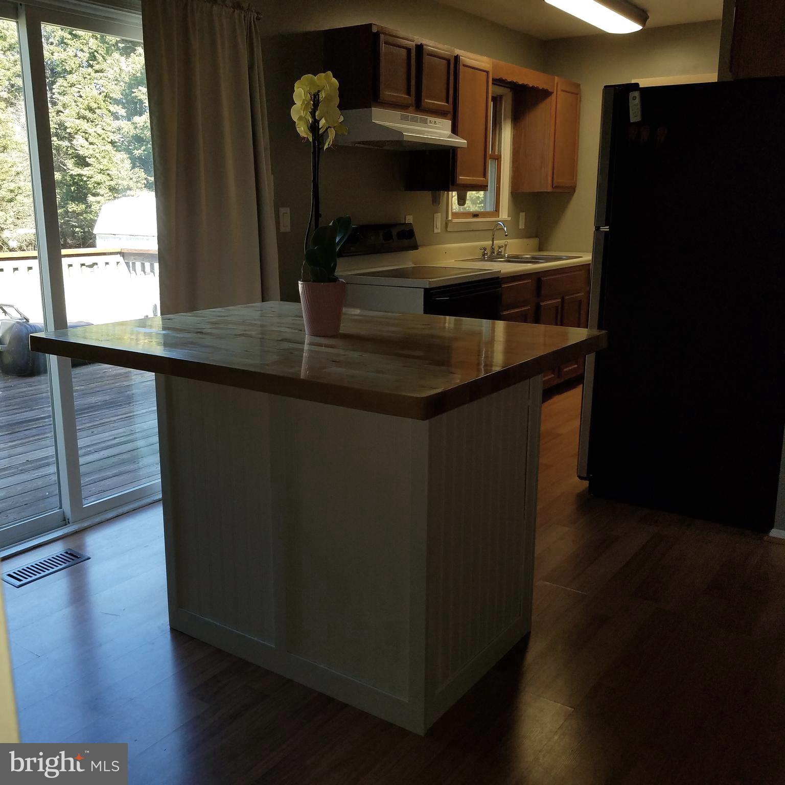 5460 Bethlehem Road Preston, MD 21655 - Photo 10 of 25 a kitchen with granite countertop a sink a refrigerator and wooden floor