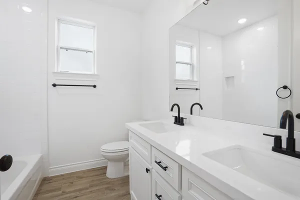 a bathroom with a sink a toilet and a window