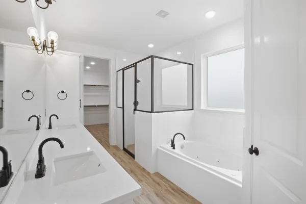 a bathroom with a tub sink and mirror