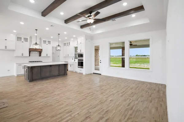 a view of an empty room with kitchen appliances and a window