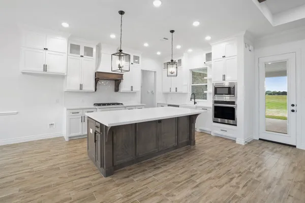 a kitchen with a sink cabinets and wooden floor