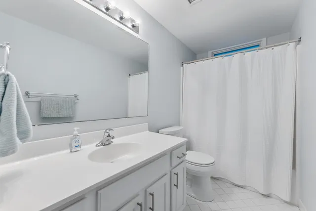 a bathroom with a sink a toilet and a large mirror