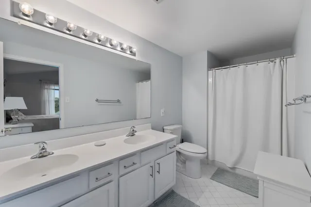 a bathroom with a double vanity sink mirror and toilet