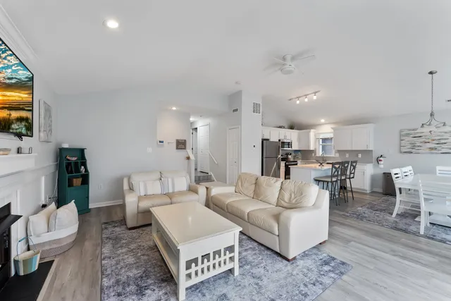 a living room with furniture a flat screen tv and kitchen view
