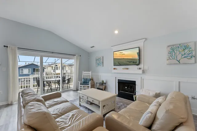 a living room with furniture a flat screen tv and a fireplace