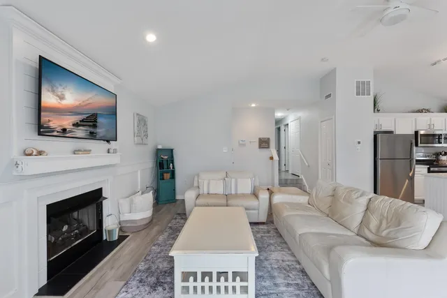 a living room with furniture a flat screen tv and a fireplace